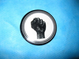 An original "protest" button from the 60's. Black clenched fist